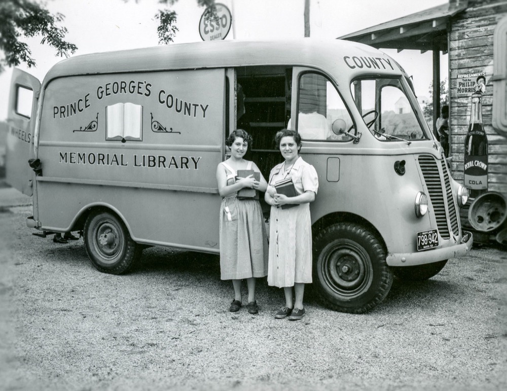 Девушки на фоне передвижной библиотеки